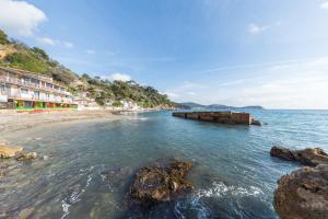 a view of a beach with rocks in the water at Appartement Les Elfes in Le Pradet