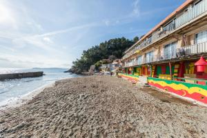 a beach with colorful buildings next to the water at Appartement Les Elfes in Le Pradet