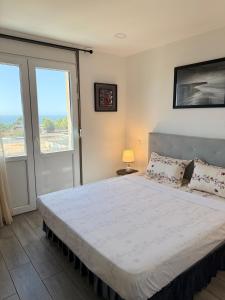 a bedroom with a large white bed with a window at Casa Mare Oureah in Mazagran