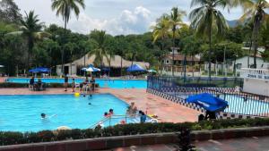 a pool at a resort with people swimming in it at Cabaña Las Lajas la pintada in La Pintada