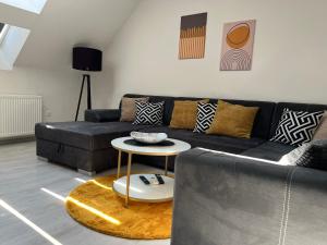 a living room with a black couch and a table at Apartment AFRODITA Trnava - Historic centre in Trnava