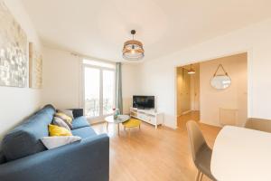 a living room with a blue couch and a tv at Appartement Les Elfes in Le Pradet +15 photos