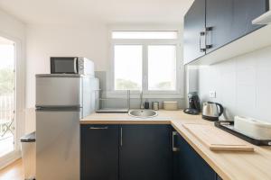a kitchen with a refrigerator and a sink at Appartement Les Elfes in Le Pradet