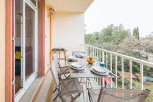 a balcony with a table and chairs on a balcony at Appartement Les Elfes in Le Pradet