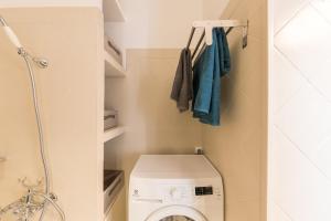 a small bathroom with a washing machine and towels at Appartement Les Elfes in Le Pradet