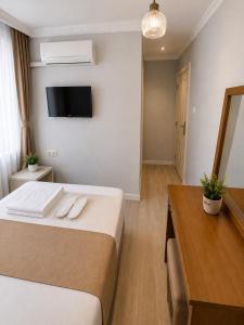 a bedroom with a bed and a desk and a television at Kennedy Apart Hotel Kumkapı Istanbul in Istanbul