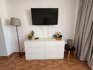 a white dresser with a flat screen tv on a wall at Marlenghi Apartments 412 in San Bartolomé
