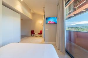 a bedroom with a bed and a large window at Elgio' Design Retreat with Etna View Taormina in Taormina