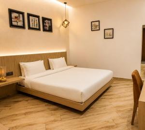 a bedroom with a large white bed and a table at The Sky Deck in Haldwāni +2 photos