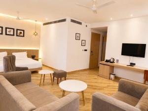 a living room with a couch and a bed and a tv at The Sky Deck in Haldwāni