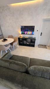 a living room with a couch and a table and a tv at CANj LOUNGE STUDIO in Čanj
