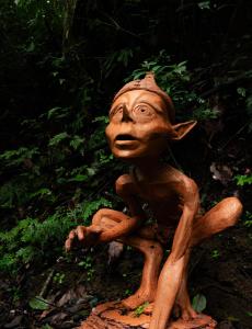 a statue of a monkey sitting on a stump at Hotel Boutique Finca La Niebla in Coatepec