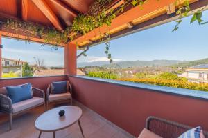 a balcony with a table and chairs and a view of the mountains at Elgio' Design Retreat with Etna View Taormina in Taormina
