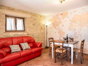 a living room with a red couch and a table at L'Uggetto in Montecastrilli