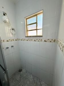 a bathroom with a shower and a window at Casa central, com 2 quartos e até 2 carros in Divinópolis