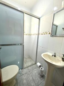 a bathroom with a shower and a toilet and a sink at Casa central, com 2 quartos e até 2 carros in Divinópolis