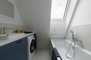 a bathroom with a sink and a washing machine at Leśne Chwile in Osiek