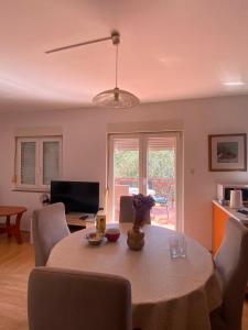 a living room with a dining room table with a tableablish at Kuća među maslinama s pogledom na more in Poljana