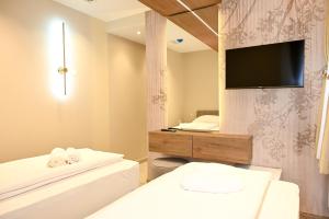 ein Badezimmer mit Fernseher, Bett und Badewanne in der Unterkunft Hotel Unca in Jajce