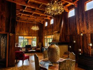 a living room with a table and a chandelier at Hotel Boutique Finca La Niebla in Coatepec