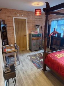 a bedroom with a bed and a desk and a table at Harry Potter feature room- Warner bros studios in Watford