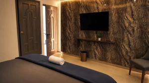 a bedroom with a bed and a television on a wall at Hotel Boutique Piedra & Altura in San Juan Teotihuacán