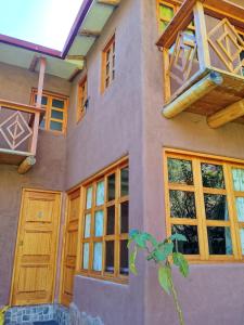 a house with wooden doors and windows on it at El molle in Pisac