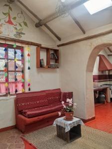 a living room with a red couch and a table at El molle in Pisac