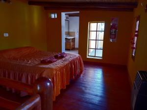 a bedroom with a bed with a redspread on it at Luminares in Humahuaca