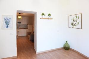 a living room with a white wall with two potted plants at Casa Nora in Valsinni +1 photo