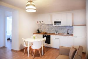 a kitchen with white cabinets and a table and chairs at Casa Nora in Valsinni