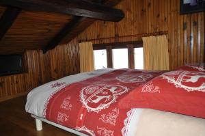 a red and white bed in a room with a window at In the heart of nature in Valdeblore