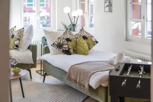 a bedroom with a bed with pillows and a chair at BASEKAMP Prime I Friends I Lake I Mountains I Luzern in Küssnacht +51 photos
