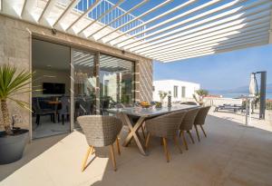 a dining room with a table and chairs on a patio at Villa Oasis mit Meerblick in Supetar