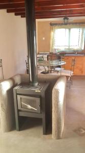 a wood stove in a room with a table at Cabañas ConSentidos in Villa General Belgrano +26 photos