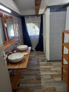 a bathroom with two sinks on a wooden counter at Escale au Salagou in Le Bosc +30 photos