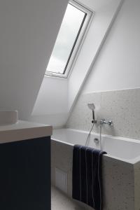 a bathroom with a bath tub and a skylight at Leśne Chwile in Osiek +35 photos