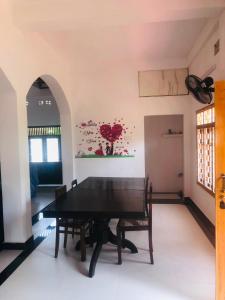 a dining room with a black table and chairs at Sanku guest house in Jaffna