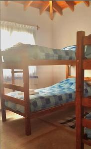 two bunk beds in a room with a window at Cabañas ConSentidos in Villa General Belgrano