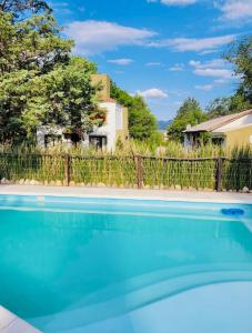 a swimming pool in front of a fence at Cabañas ConSentidos in Villa General Belgrano