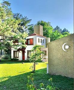 a large house in the middle of a yard at Cabañas ConSentidos in Villa General Belgrano