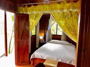 a bedroom with a canopy bed and a window at Cabañas Los Laguitos Rio Celeste in El Achiote +7 photos