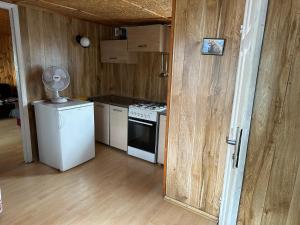 a kitchen with a white stove and a refrigerator at Domki ALKANA - domek 3 in Nowęcin