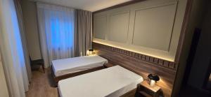 a small room with two beds and a window at Drei Schweizer Hotel in Neuwied
