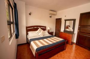 a small bedroom with a bed and a mirror at Hotel Rivera Plaza in Cali