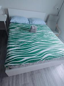 a bed with a green and white striped blanket at Central Light-Filled 3rd Floor -3C in Halifax