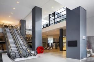 an escalator in the lobby of a building at NH Collection Curitiba in Curitiba