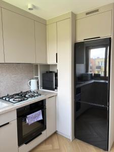 a kitchen with white cabinets and a stove top oven at Apartament Opoczno in Opoczno