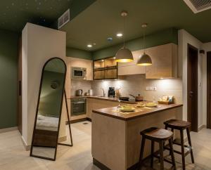 a kitchen with a counter and two bar stools at Hotel Mashabrum Skardu in Skardu