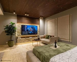 a living room with a large bed and a tv at Hotel Mashabrum Skardu in Skardu +3 photos